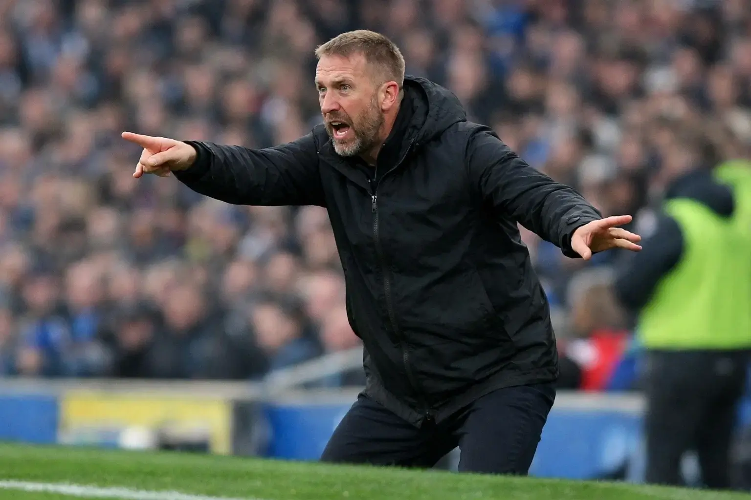 Football manager giving instructions to players on the sideline during match